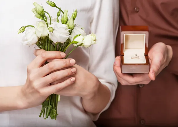 Düğün çifti holding yüzük kutusu ve bir buket çiçek — Stok fotoğraf