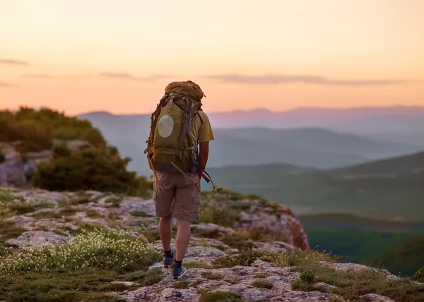 Guy in the mountains at sunset. the concept of freedom — Stock Photo, Image