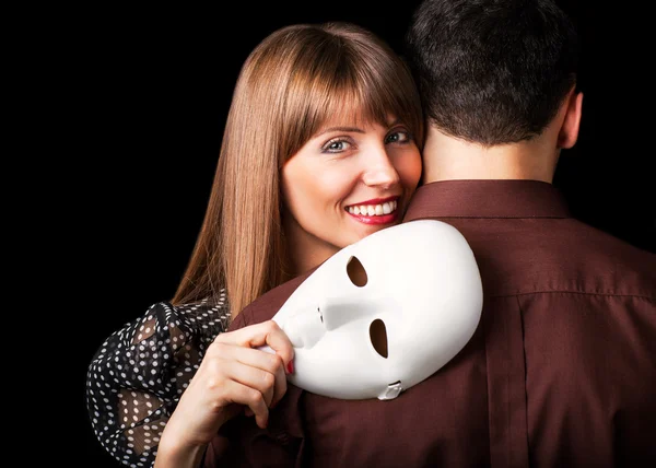 Moda Casal feliz no amor segurando um rosto de máscara branca . — Fotografia de Stock