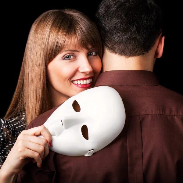 Moda Casal feliz no amor segurando um rosto de máscara branca . — Fotografia de Stock