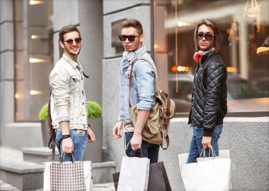 Üç genç erkek moda metraseksuals Dükkanı. Erkekler yürüyüş alışveriş.