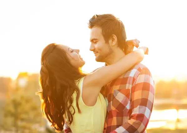 Pareja joven enamorada caminando en el parque cerca del río . —  Fotos de Stock