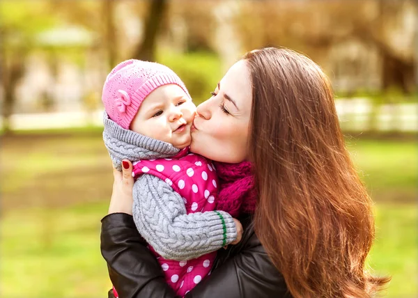 Mamma kysser hennes dotter i parken — Stockfoto