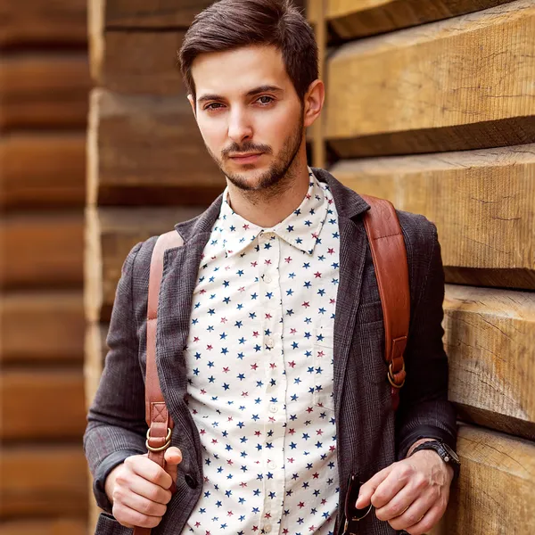 Retrato de jovem belo homem elegante contra a parede de madeira . — Fotografia de Stock