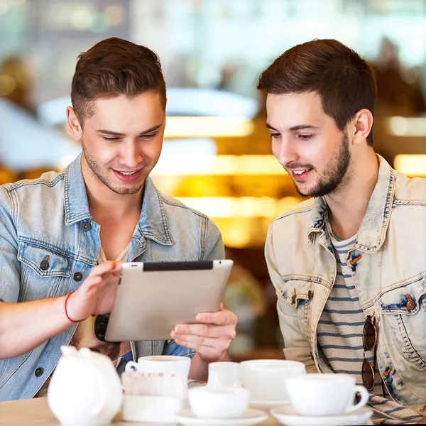 Estudiante joven usando tableta en la cafetería —  Fotos de Stock