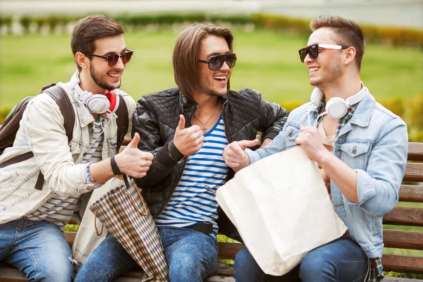 Tres hombres jóvenes metraseksuals tienda de moda. Los hombres de compras caminar . — Foto de Stock