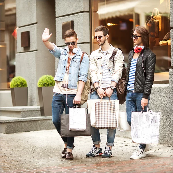 Tres hombres jóvenes metraseksuals tienda de moda. Los hombres de compras caminar . — Foto de Stock