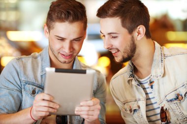 bir kafede, tablet bilgisayar kullanan iki genç öğrenciler