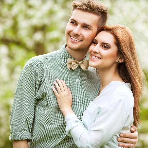 Verliebtes Paar im blühenden Apfelbaumgarten, lächelnd — Stockfoto
