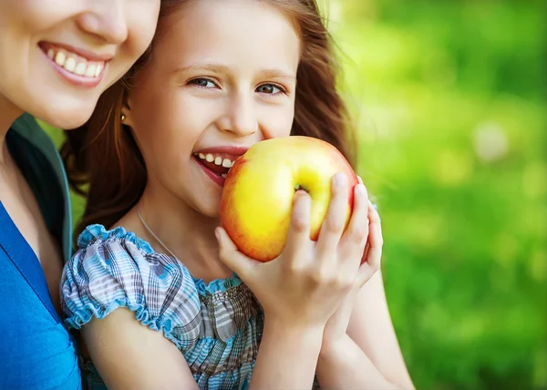 Mother and her child enjoy the early spring, eating apple, happy — Stock Photo, Image