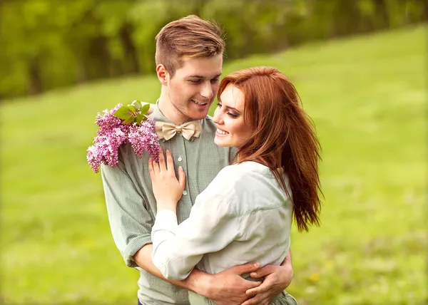 Par i kärlek i blommande äppelträd trädgård, leende — Stockfoto