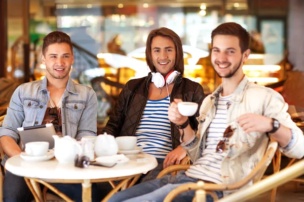 ชายหนุ่มฮิปสเตอร์นั่งอยู่ในคาเฟ่ คุยกันและดื่มกาแฟ — ภาพถ่ายสต็อก