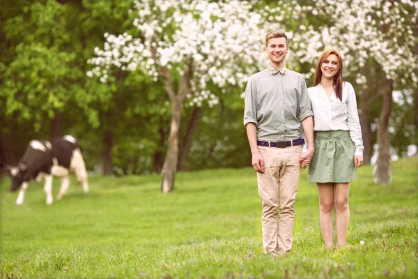 Couple in love in blooming apple trees garden, smiling. — Stock Photo, Image