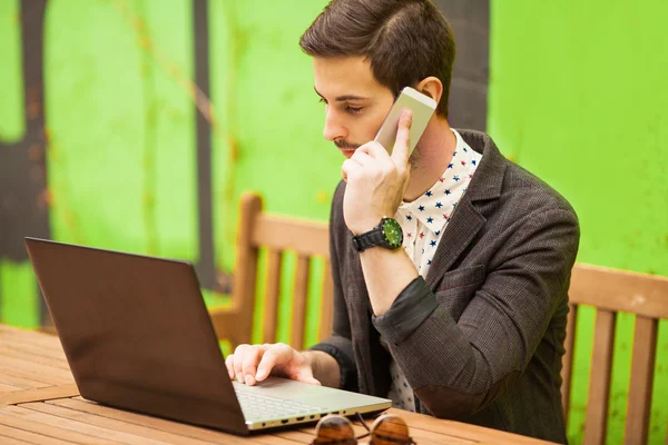 Glücklicher Mann, der im Café am Laptop arbeitet — Stockfoto