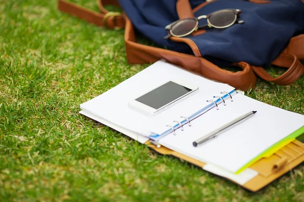 Notebook digital moderno com smartphone móvel na grama verde — Fotografia de Stock