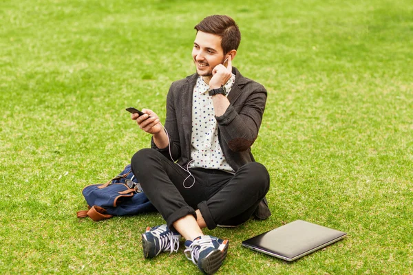 Chico escuchando a jugador en verde parque — Foto de Stock