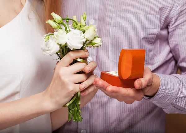 Wedding couple holding ring box and a bouquet of flowers — Stock Photo, Image