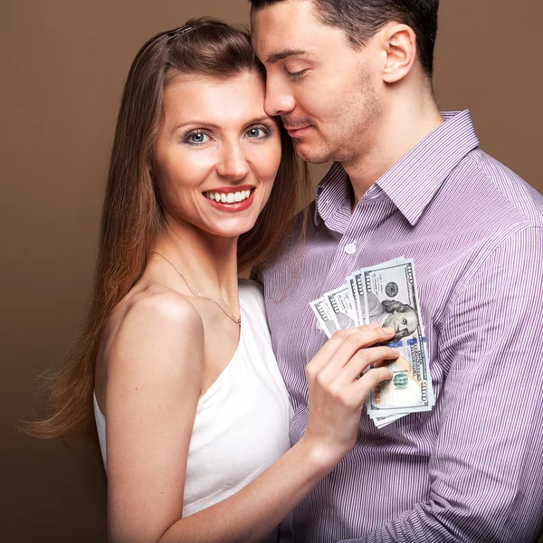 Fashion beautiful couple in love holding money the family budget — Stock Photo, Image