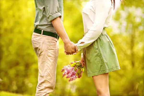 Молодая пара влюбленных гуляет по осеннему парку, держась за руки. — стоковое фото