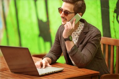 mutlu bir adam café laptop üzerinde çalışıyor