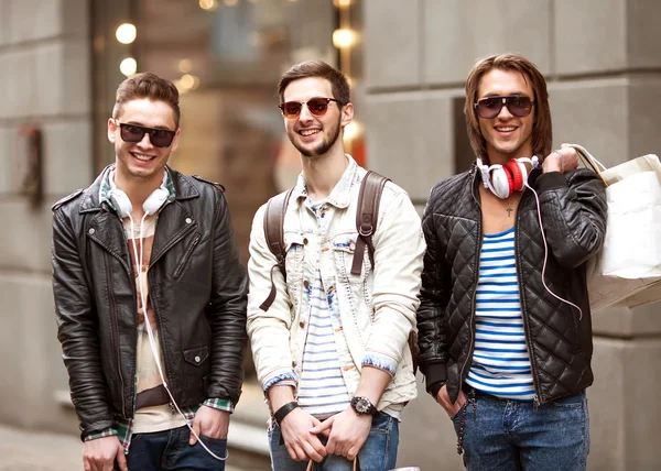 Tres hombres jóvenes metraseksualy moda tienda de compras a pie — Foto de Stock