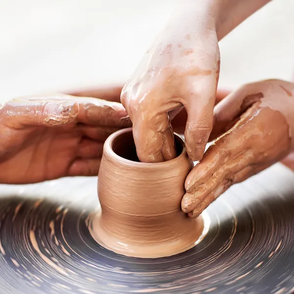 Potter ruce do hlíny na hrnčířského kruhu. — Stock fotografie