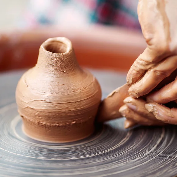 Potier fabrication des mains en argile sur roue de poterie . — Photo