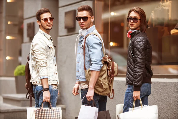 Tres hombres jóvenes metraseksuals moda tienda de compras a pie —  Fotos de Stock