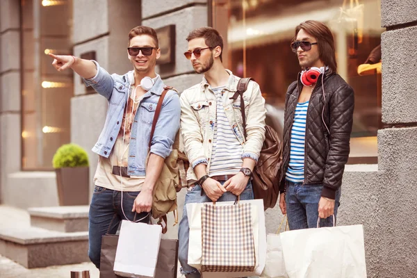 Tres hombres jóvenes metraseksuals moda tienda de compras a pie —  Fotos de Stock