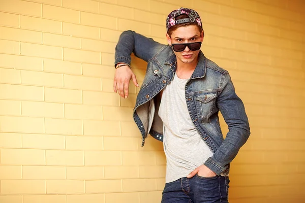 Sexy homem de moda com barba vestido casual sorrindo contra a parede — Fotografia de Stock