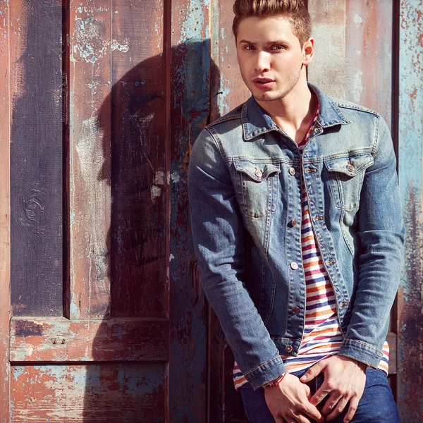 Portrait of young beautiful fashionable man against wooden wall. — Stock Photo, Image