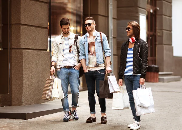 Tres hombres jóvenes tienda de moda paseo de compras — Foto de Stock