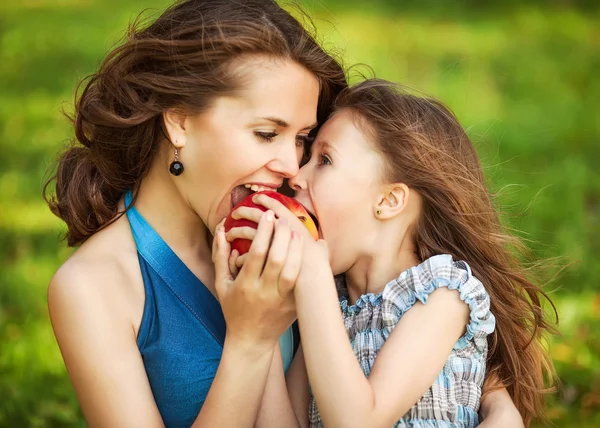 Matka i jej dziecko cieszyć się wczesną wiosną, jabłko jedzenie, szczęśliwy — Zdjęcie stockowe