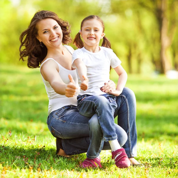 Mother and daughter enjoy the early spring show sign of OK — Stock Photo, Image
