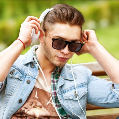 yakışıklı moda adam parkta çim müzik dinlemek