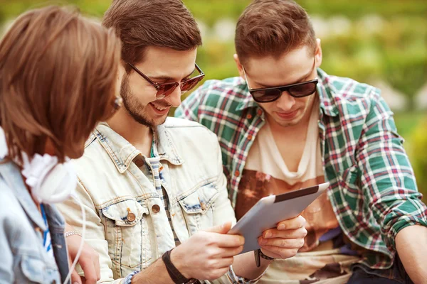 Young men friends using tablet computer in park — Stock Photo, Image