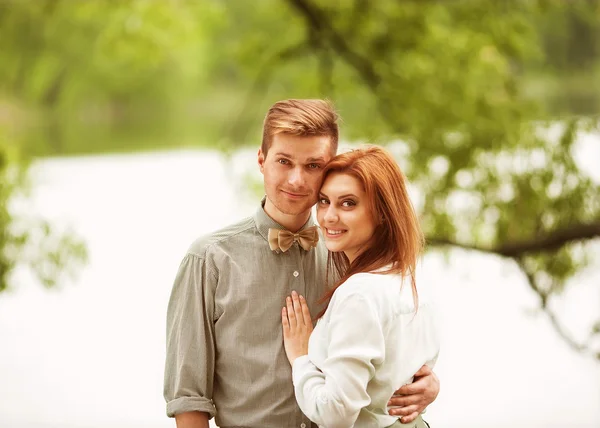 Pareja enamorada sentada cerca del río, picnic —  Fotos de Stock