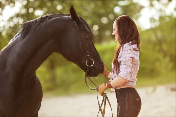 Jeune femme avec un cheval dans le parc près de la rivière — Photo