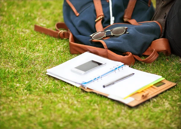 Moderna digitala anteckningsboken med rörlig smartphone på grönt gräs — Stockfoto