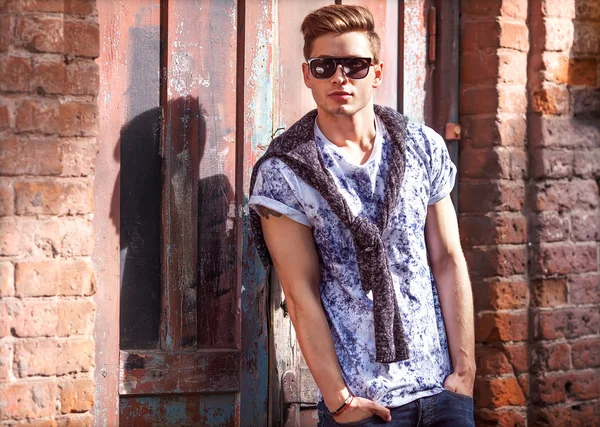 Hipster style guy. Fashion man standing near a wooden door — Stock Photo, Image