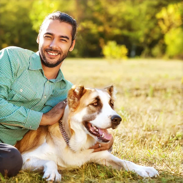 Mann und zentralasiatischer Schäferhund spazieren im Park. — Stockfoto