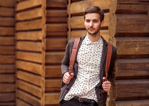 Ritratto di giovane bello uomo alla moda contro muro di legno . — Foto Stock