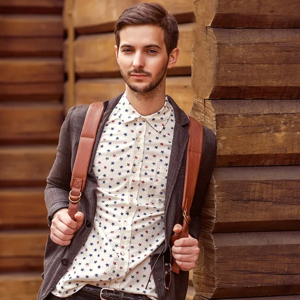 Πορτρέτο του νεαρού όμορφου άντρα της μόδας ενάντια σε ξύλινο τοίχο. — Φωτογραφία Αρχείου