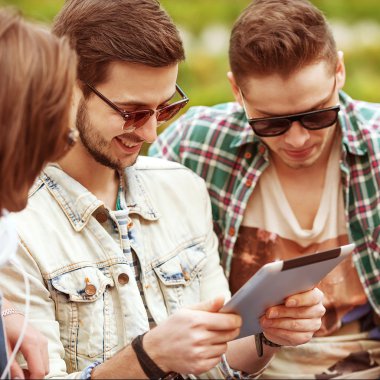 genç erkek arkadaşlarım parkta tablet bilgisayar kullanarak