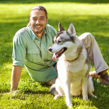 İnsan ve Husky köpeği parkta yürüyor..