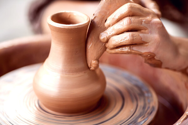 Hands working on pottery wheel , retro style toned