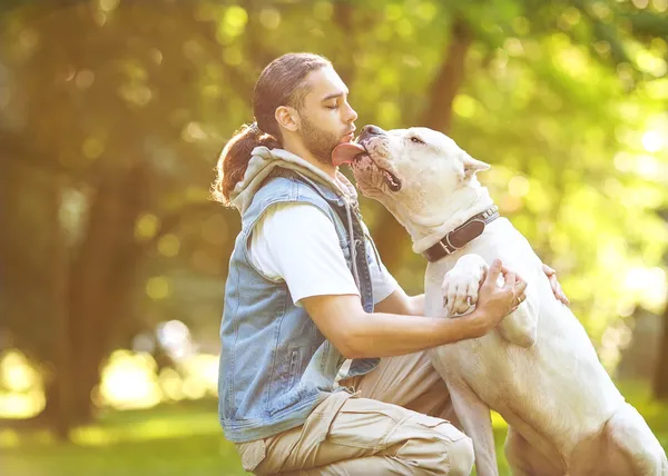 Människa och hund argentino promenad i parken. — Stockfoto