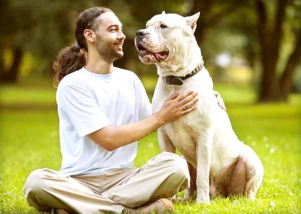 Människa och hund argentino promenad i parken. — Stockfoto