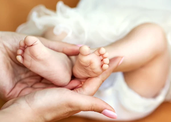 Pieds de bébé taillés dans les mains des mères . — Photo