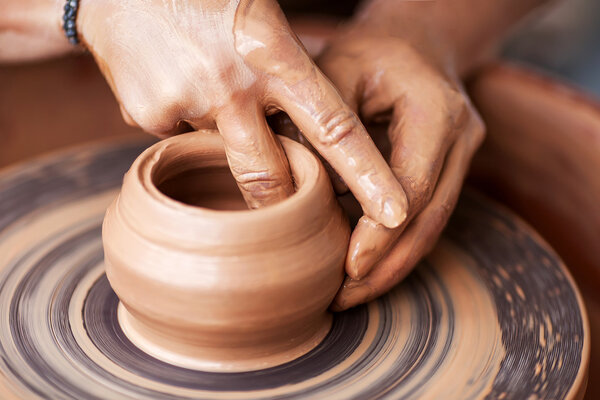 Hands working on pottery wheel